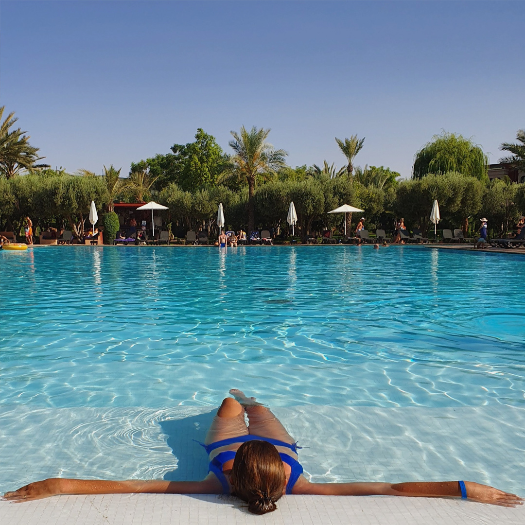 Femme allongée sur la grande piscine de l'Eden Aquapark Eden Andalou 5 etoiles SPA, suites and aquapark Marrakech ALL inclusive